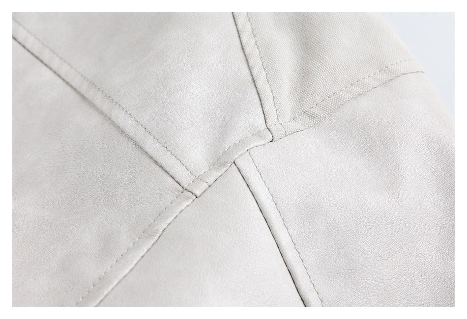 Close-up of intersecting stitched seams on light gray fabric.