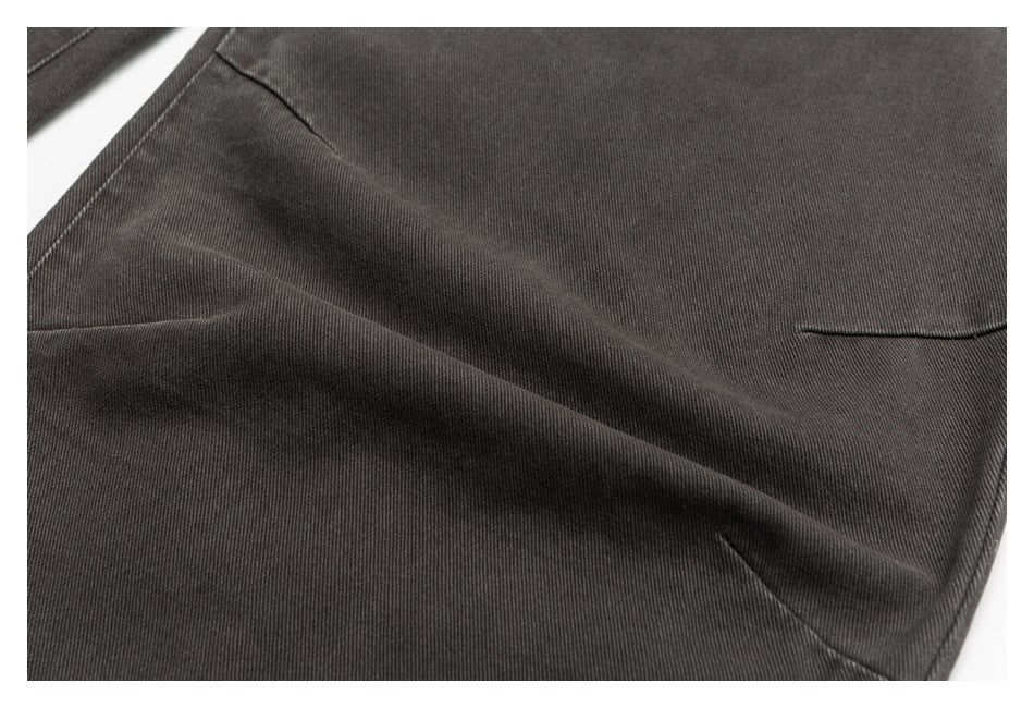 Close-up of charcoal-gray jeans fabric with a folded section, visible stitching, and a small pocket opening.