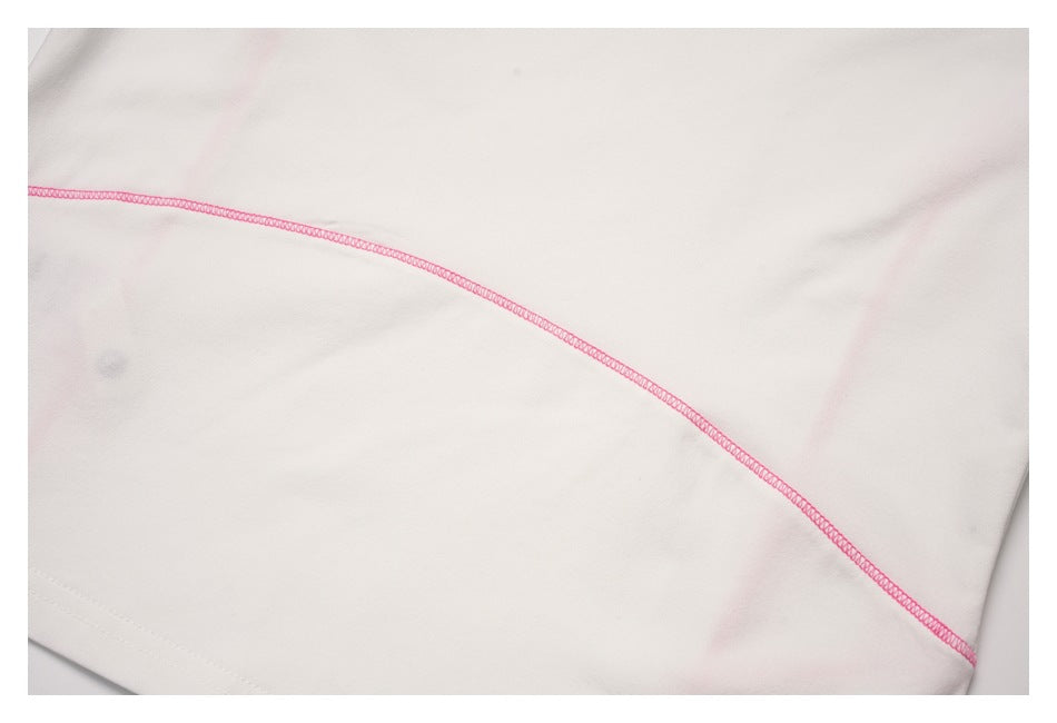 Close-up of a white garment with a curved pink overlock seam.