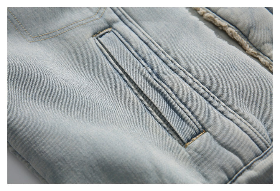 Close-up of a stitched vertical pocket on the light-wash denim jacket.