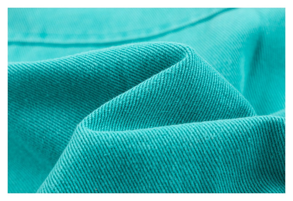 Macro view of the turquoise jacket fabric showing its textured diagonal weave.
