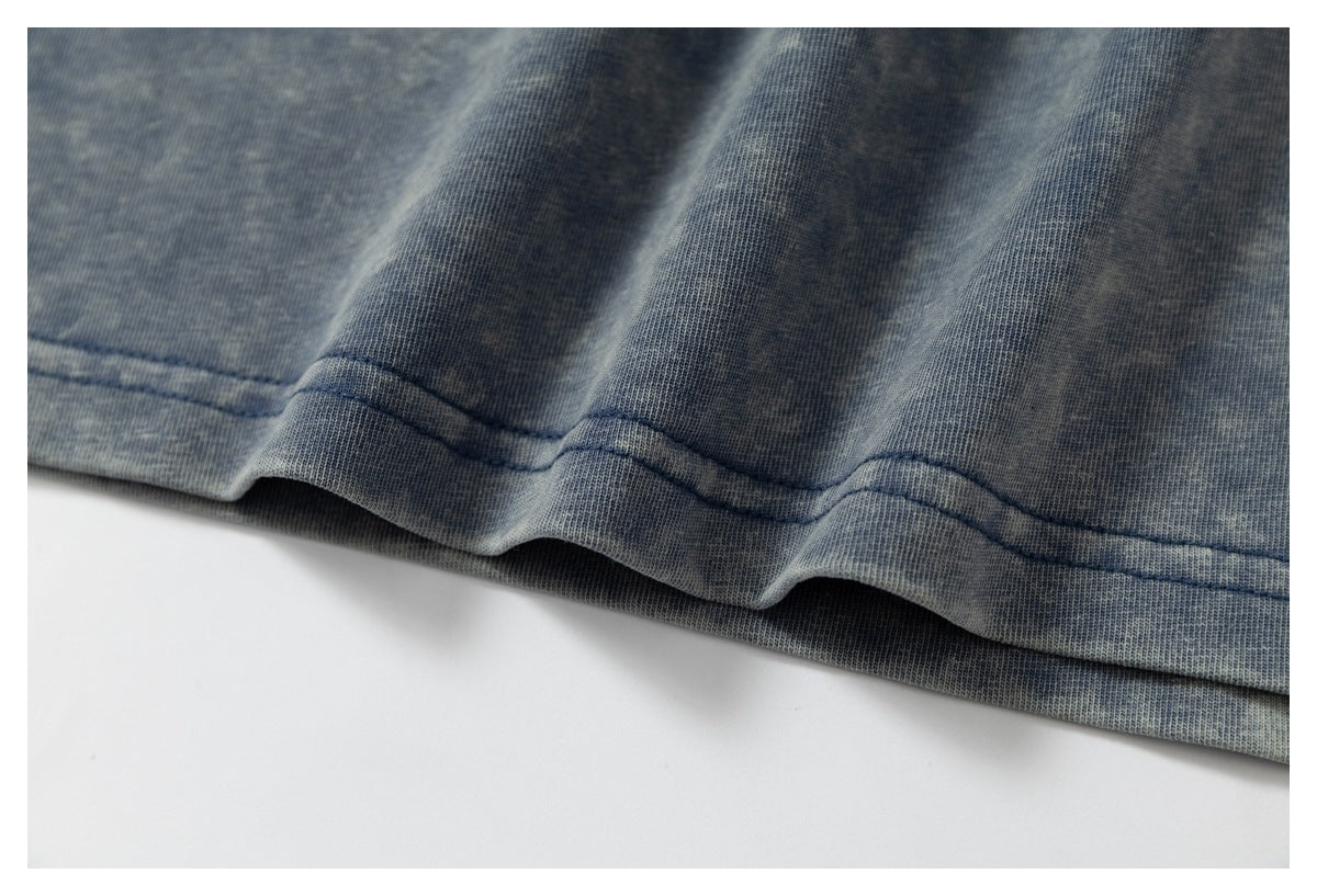 Close-up of a double-stitched hem on blue-gray mottled fabric.