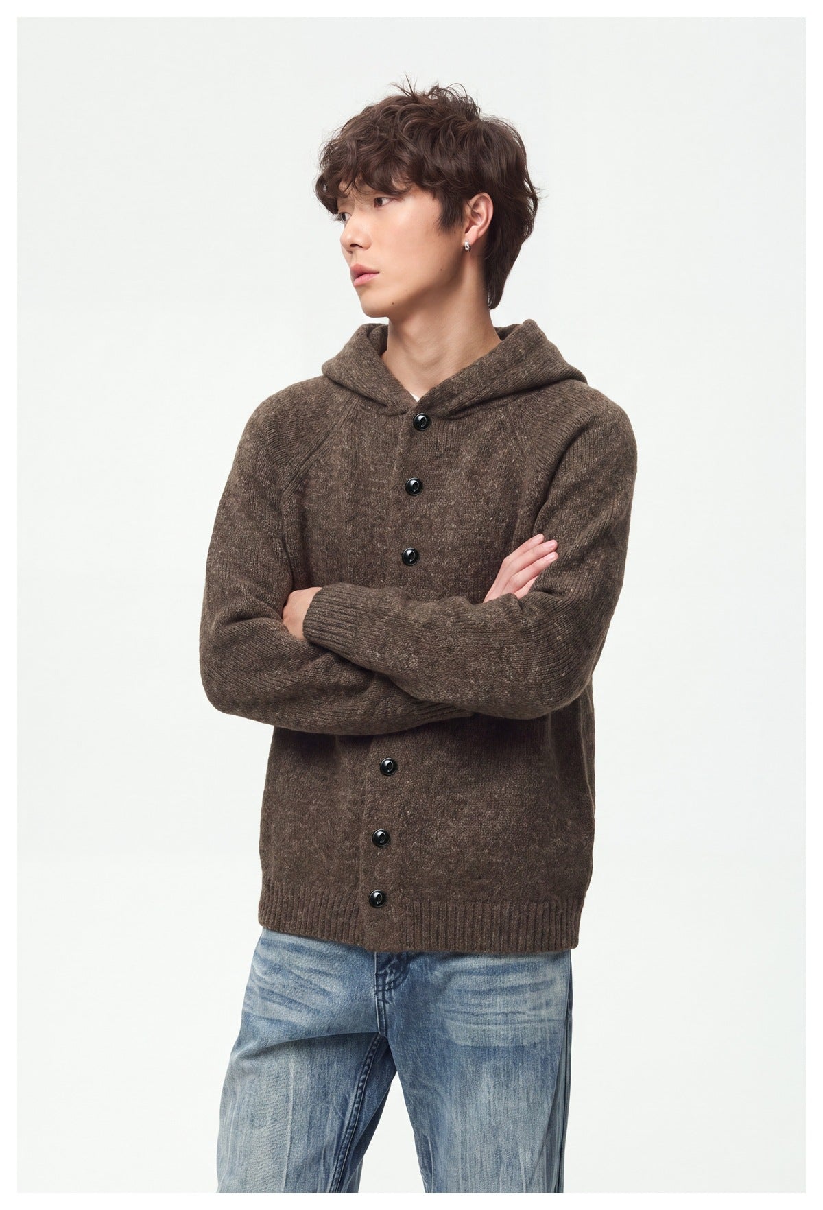 Close view of a model wearing a brown hooded cardigan with black buttons and ribbed cuffs.
