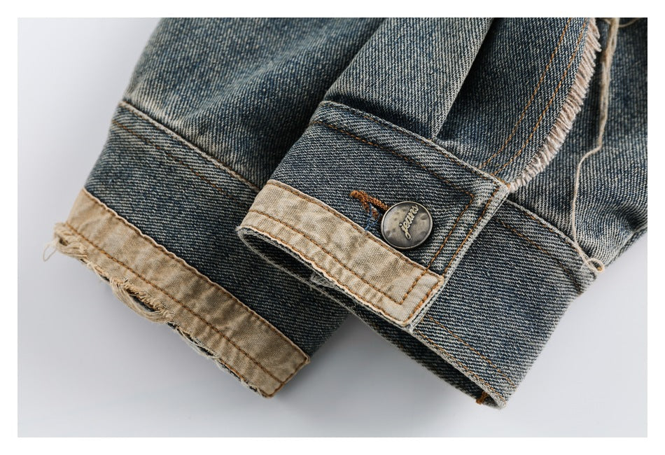 Close-up of blue denim cuffs with tan lining, frayed edges, orange stitching, and a metal button.