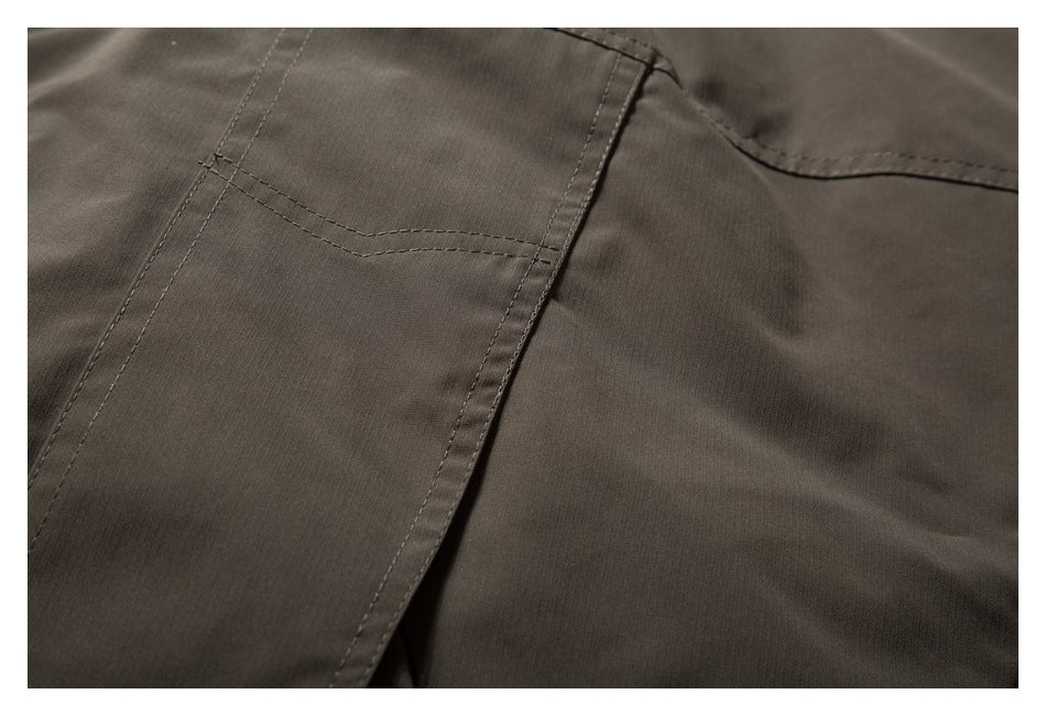 Close-up of a dark taupe jacket pocket with visible stitching and panel seams.