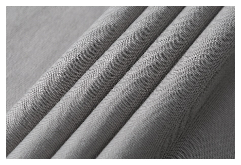 Close-up of gray fabric draped in folds, showing its fine knit texture.