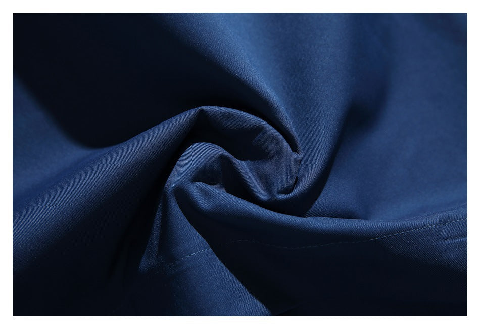 Close-up of navy fabric gathered into a fold, showing its smooth surface and stitching.