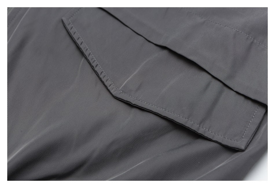 Close-up of a gray garment pocket with a stitched flap.