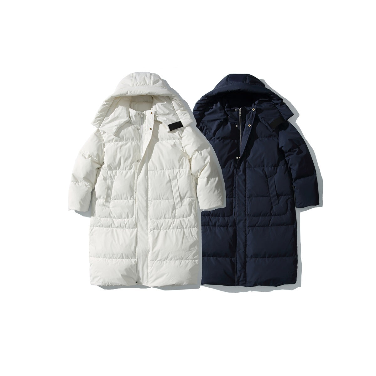 Long quilted hooded coats shown side by side in ivory and dark navy.