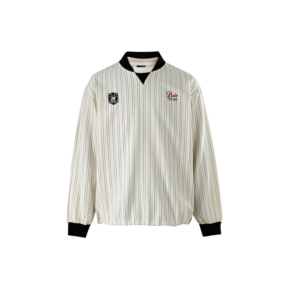 Front view of a cream jacket with fine dark pinstripes, black collar and cuffs, and chest emblems.