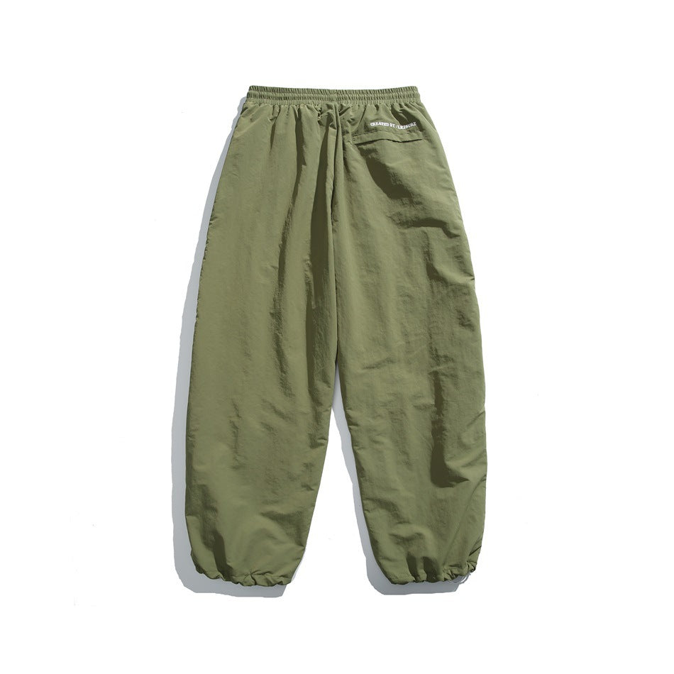 Rear view of olive green jogger pants with an elastic waist, a small back pocket, and gathered ankle cuffs.