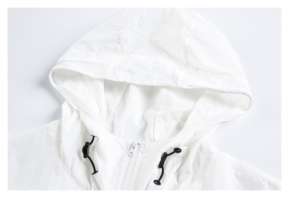 Close-up of a white jacket hood with black drawcords and a white front zipper.