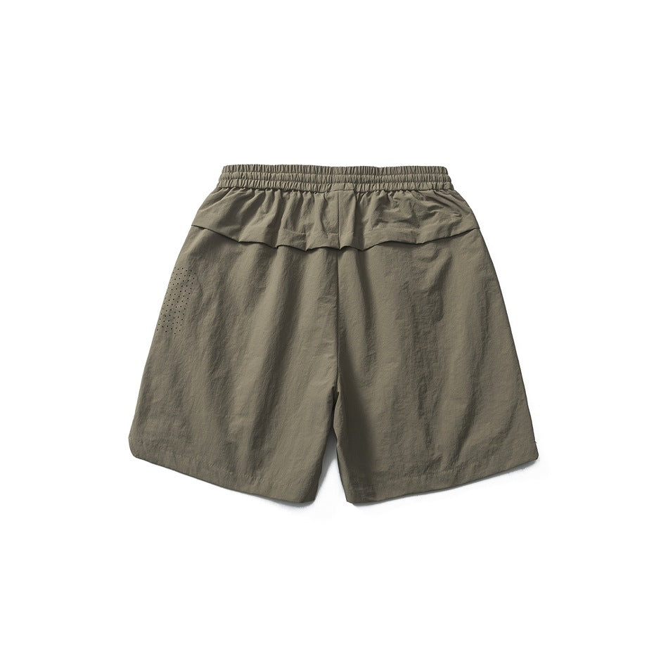 Back view of gray khaki shorts with elastic waistband, back yoke seam and perforated dot detail on one leg
