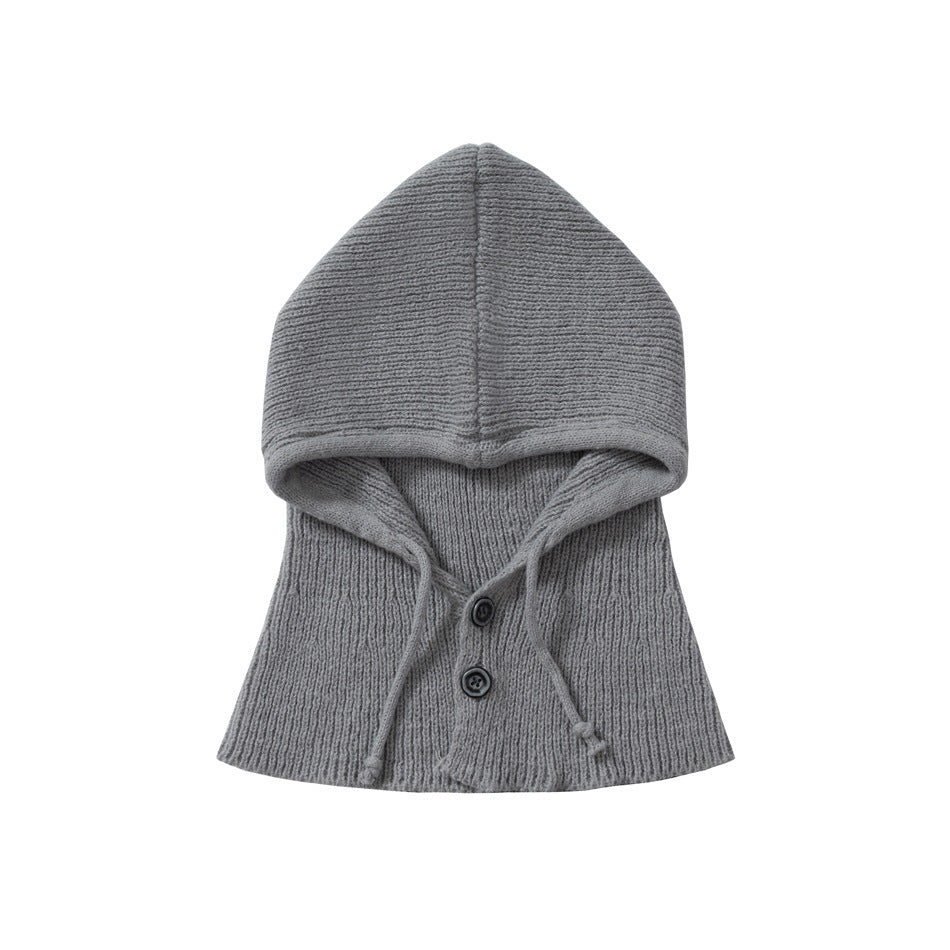 Gray rib-knit hood and neck warmer with two dark buttons and long drawstrings, shown against a white background.