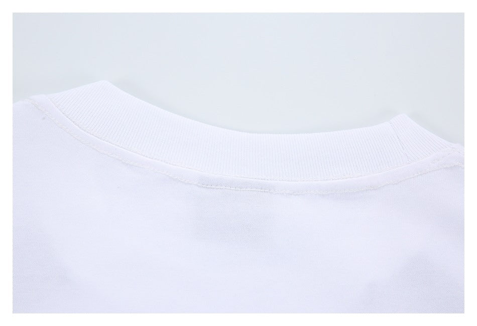 Close-up of a white garment's ribbed crew neckline and inner stitching.