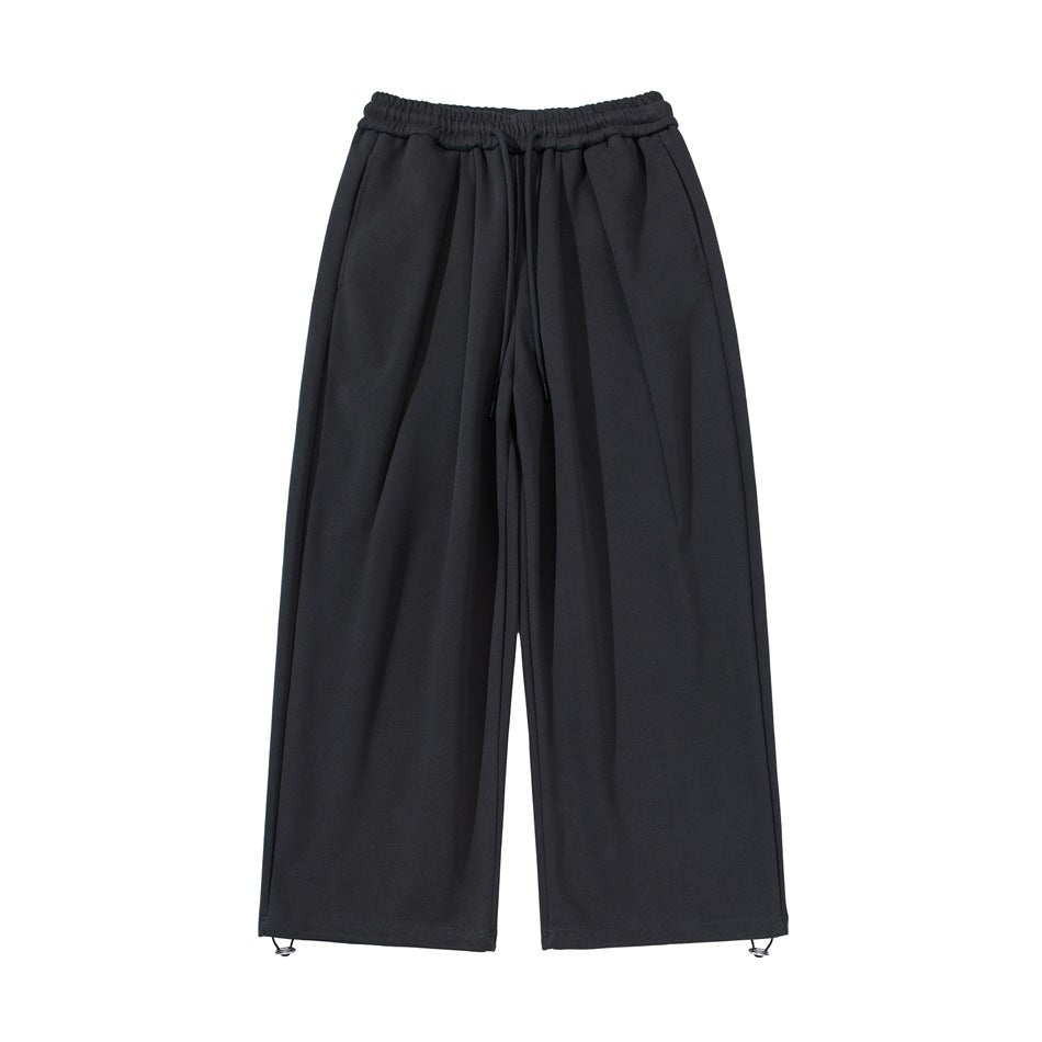 Black wide-leg drawstring sweatpants, flat front view with elastic waistband and toggle hems
