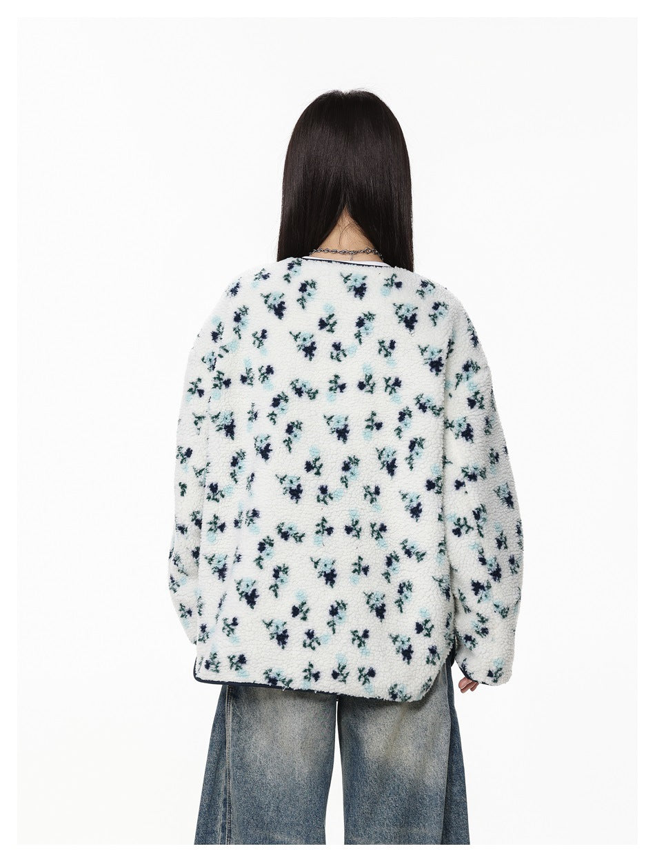 Rear view of a model showing the white floral fleece jacket with navy edging and loose blue jeans.