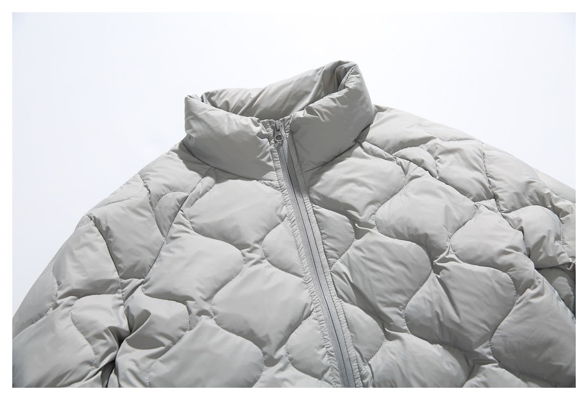 Close-up of a light gray quilted jacket's high collar, front zipper, and rounded quilting.