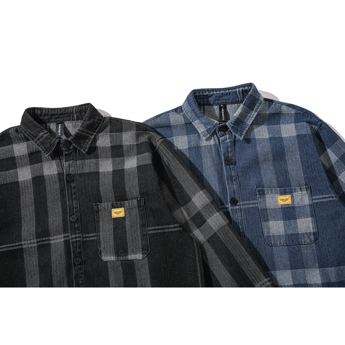 Close front view of black-and-gray and blue plaid button-up shirts with chest pockets and small yellow patches.