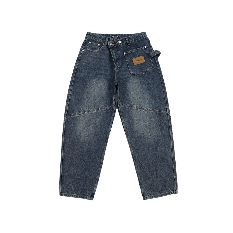 Blue washed denim jeans, front flat view with asymmetric waistband, patch pocket and knee seams