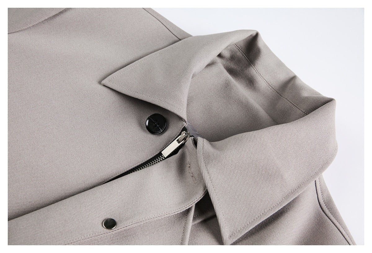 Close-up of the taupe-gray coat collar, black button, and partially visible zipper.