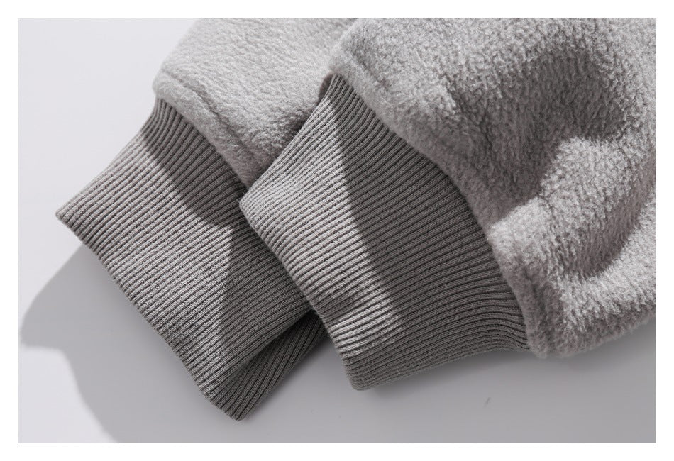 Close-up of two ribbed gray cuffs on a light gray fleece garment.