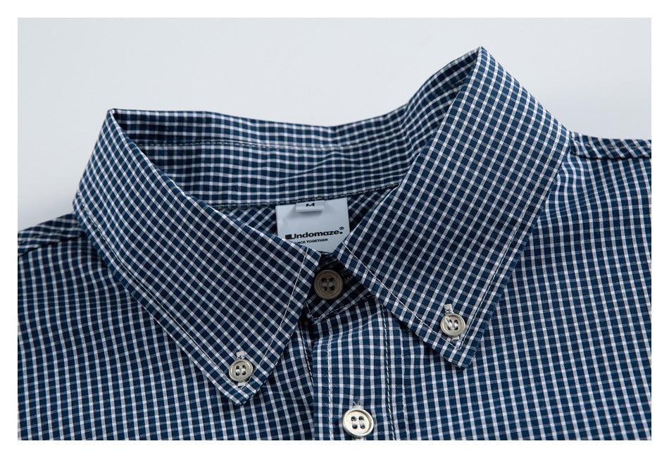 Close-up of a navy-and-white gingham shirt collar, button-down points, and neck label.
