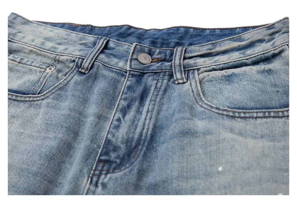 Partial front view of light blue washed jeans, showing the waistband, button, fly, and front pockets.