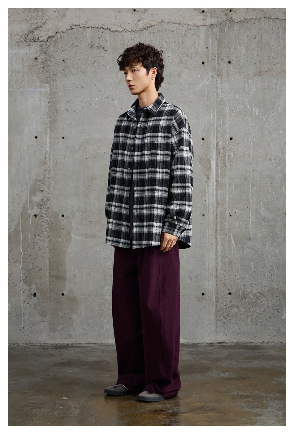Model wearing a black-and-white plaid button-up shirt, shown at a three-quarter angle.