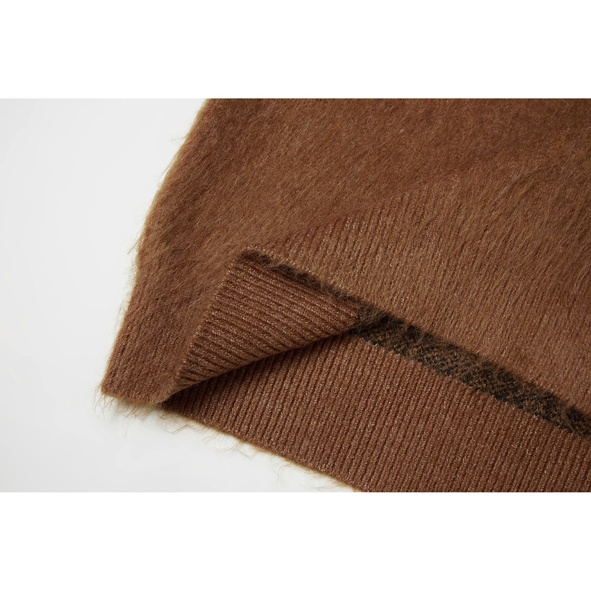 Close-up of brown knit fabric and a ribbed hem with a dark patterned edge.
