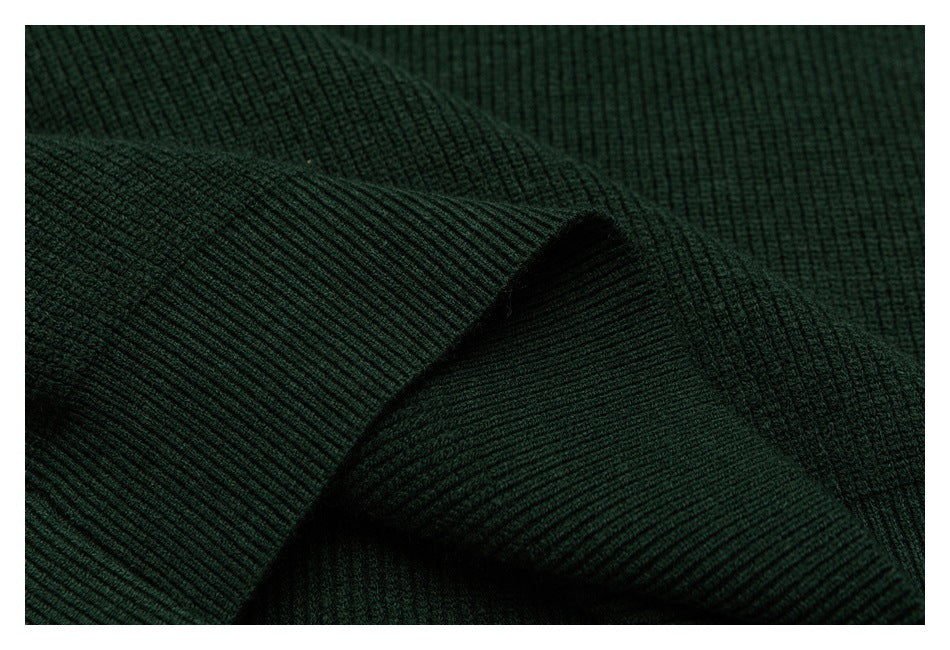 Close-up of folded dark green rib-knit fabric showing its raised texture.
