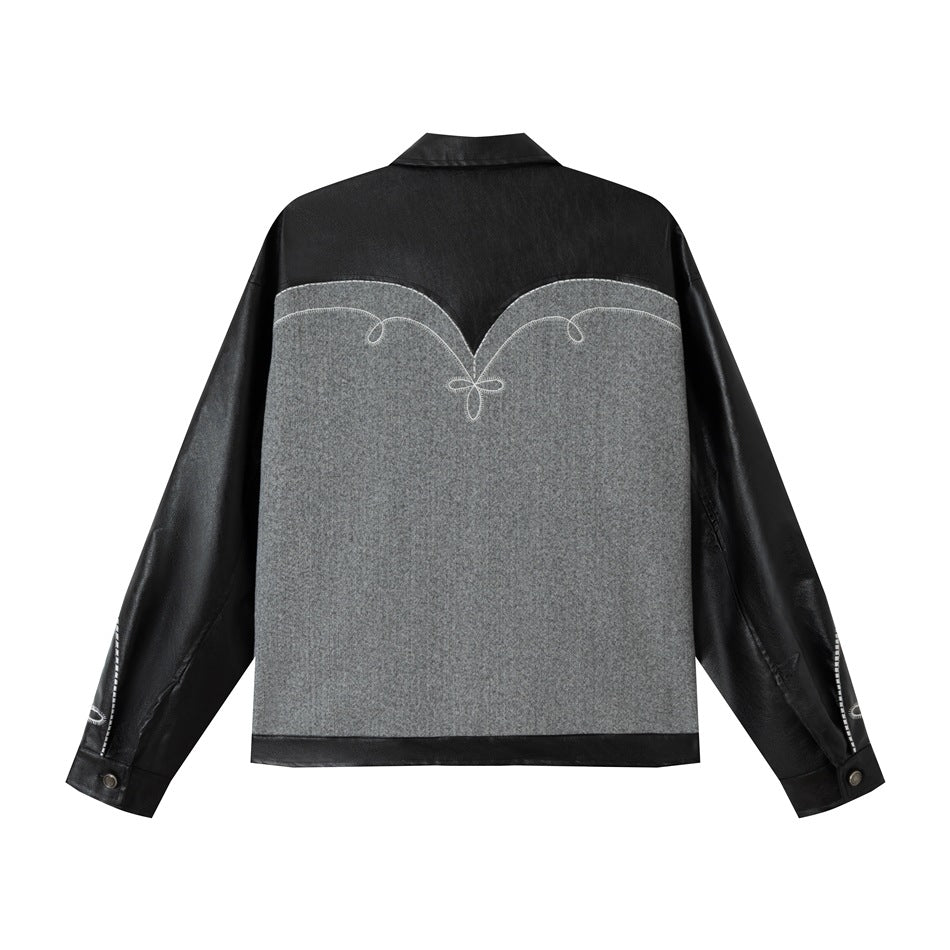 Back view of a black jacket with a large gray panel, white loop embroidery, black sleeves, and a pointed collar.
