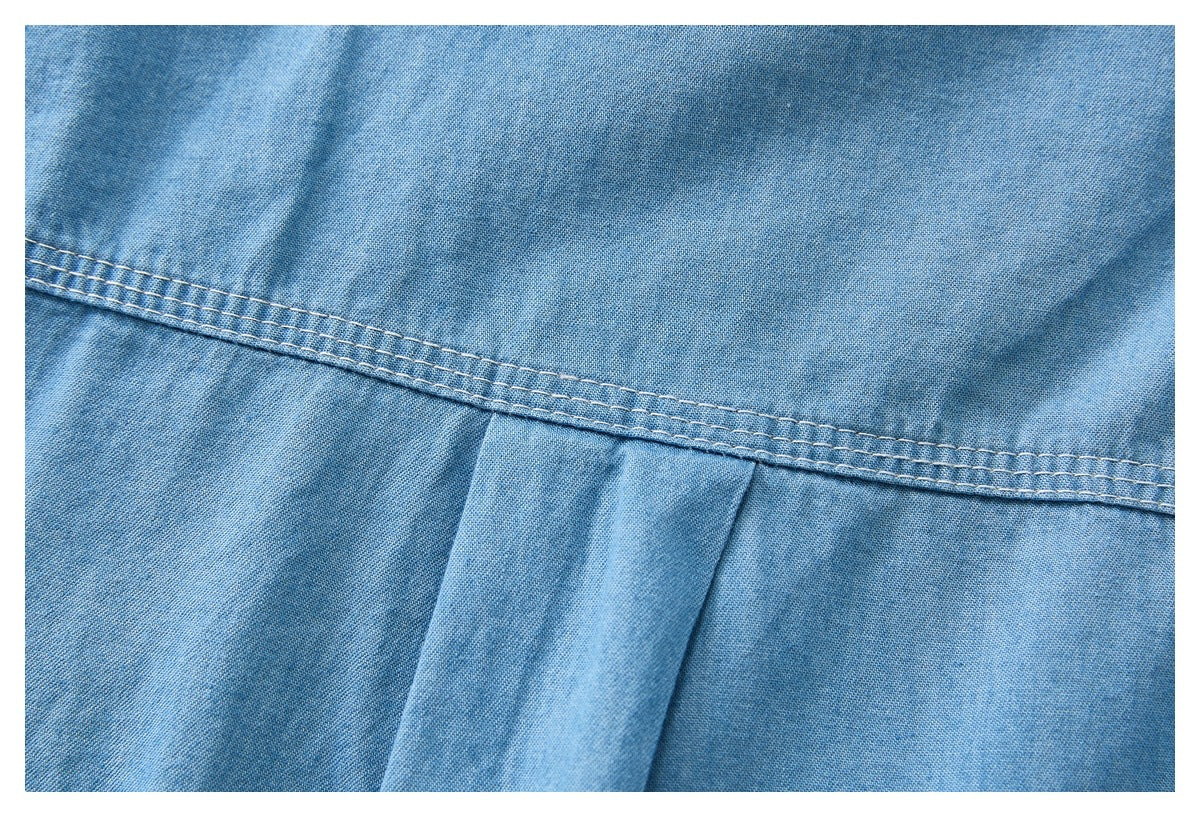 Close-up of a light blue shirt's back yoke seam and center pleat.