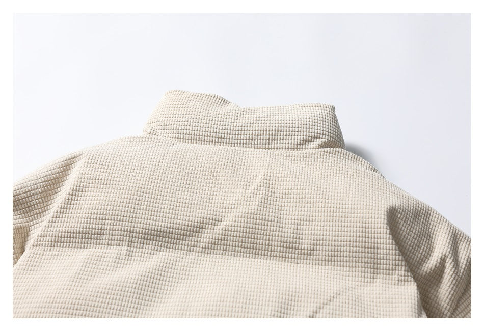 Close-up of the beige jacket's raised collar and upper back, showing its grid texture.
