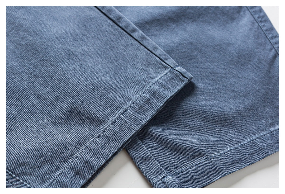Close-up of blue pants showing the stitched leg hems and fabric seams.