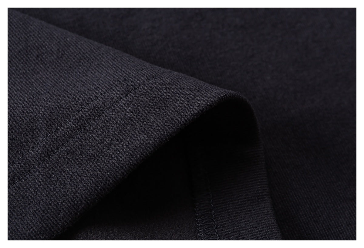 Close-up of a dark garment hem showing the fabric texture and overlocked seam.