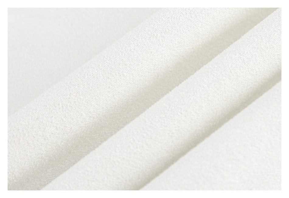 Macro close-up of the textured white garment surface and a raised seam.