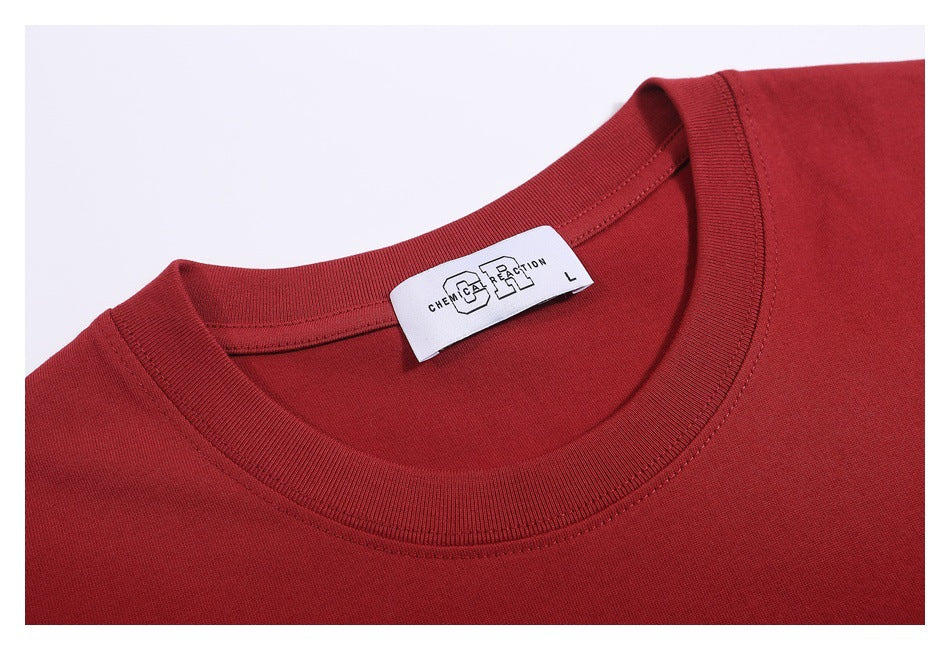 Close-up of a dark red T-shirt’s ribbed crew neck and sewn-in white label.