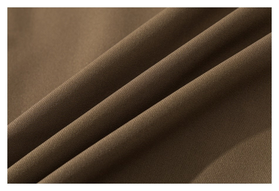 Close-up showing the brown garment fabric's surface and draped folds.