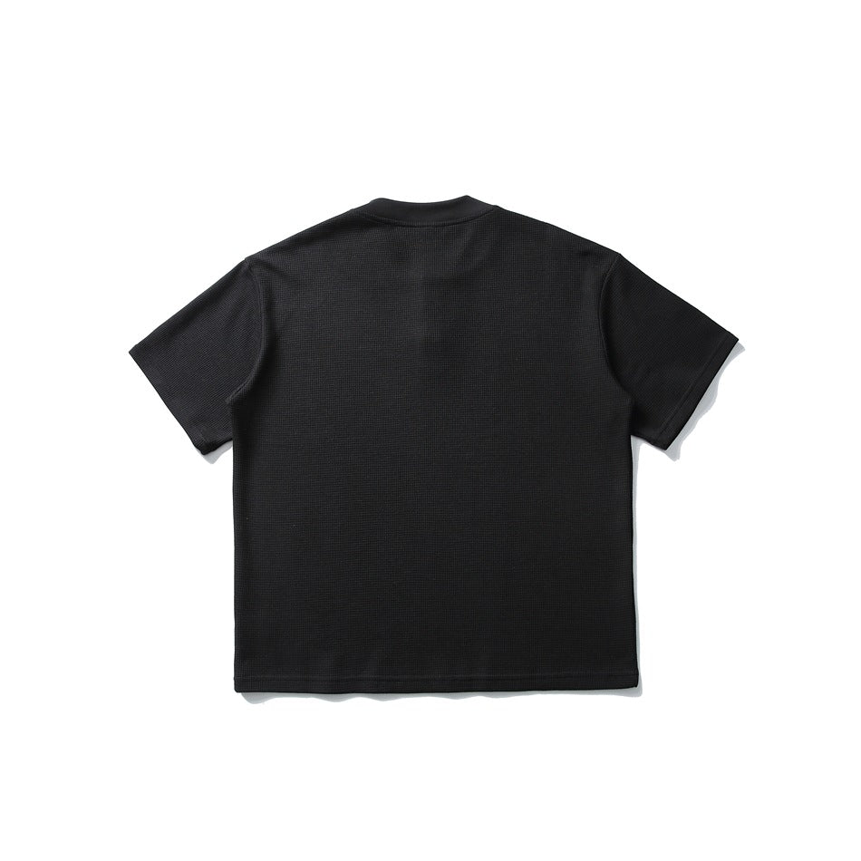 Back view of black waffle-knit short-sleeve tee with rounded band collar, flat lay