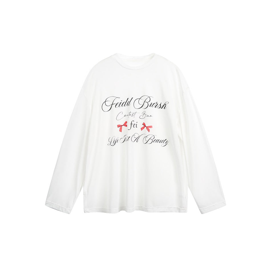 White long-sleeve top flat lay with black script print and two red bows on the front