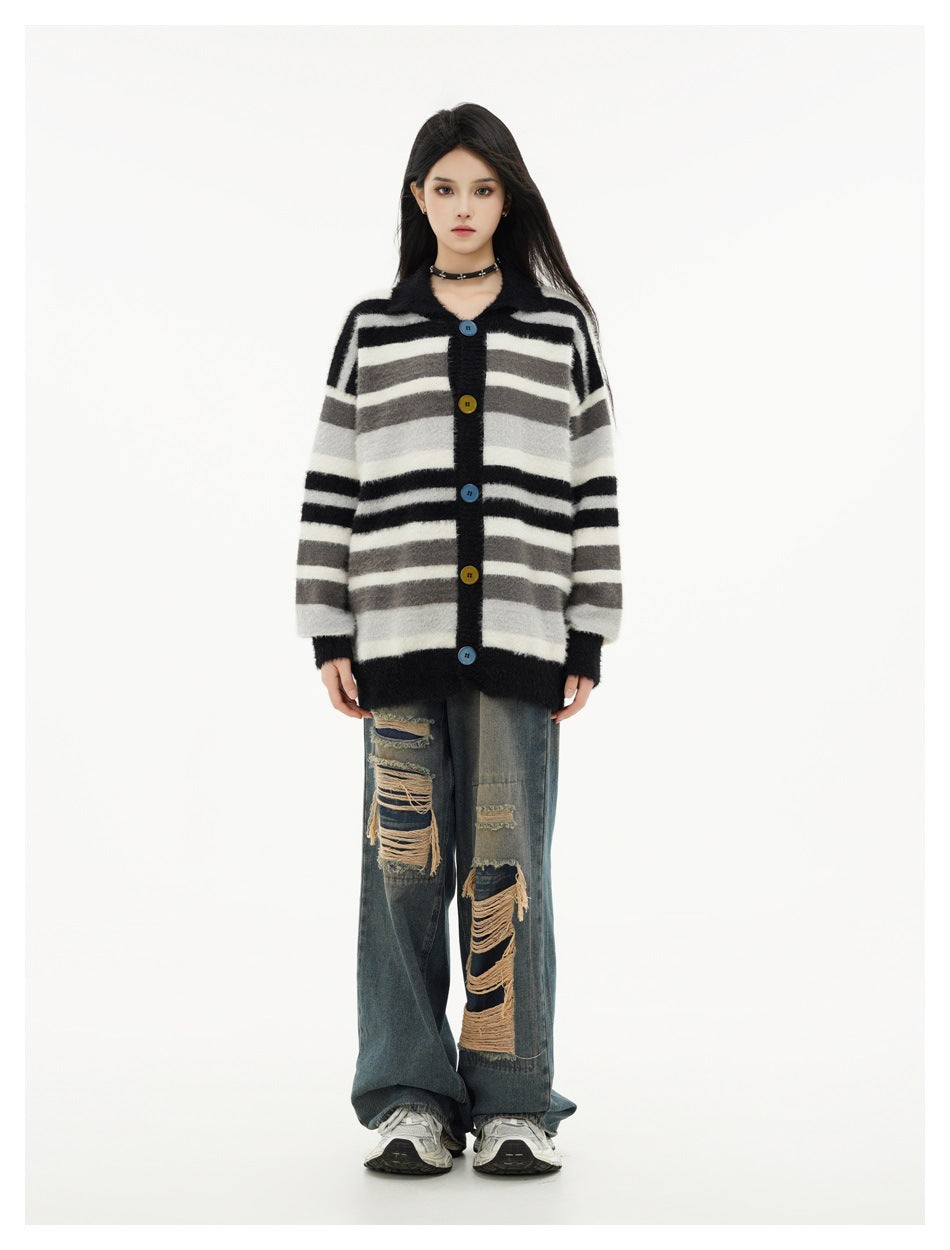 Front view of a model wearing an oversized black, gray, and cream striped cardigan with colorful buttons.