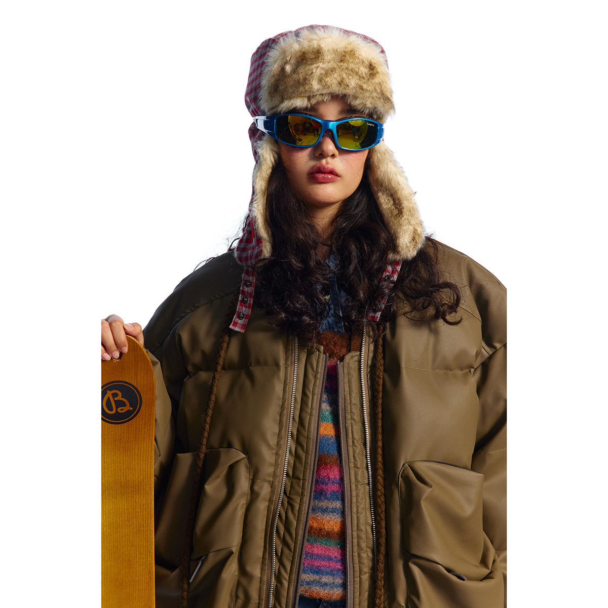 Close view of a model wearing an olive-brown puffer jacket with a front zip and large pockets.