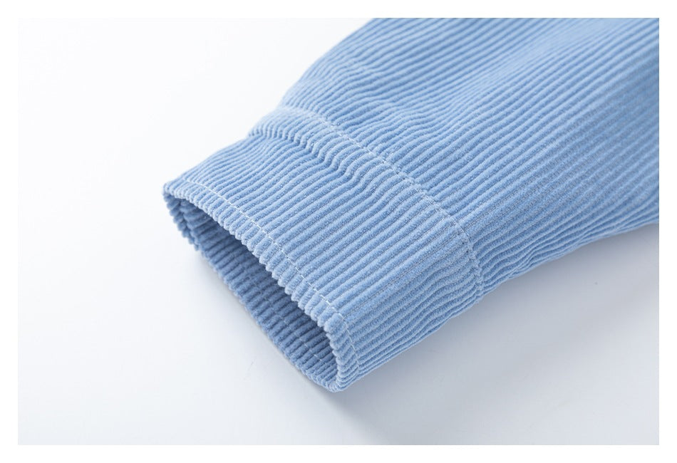Close-up of a folded cuff on a light blue ribbed corduroy sleeve.