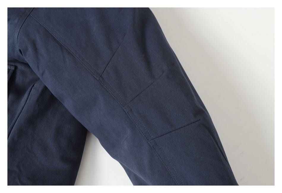 Close-up of a navy sleeve showing stitched panel seams and a rectangular sleeve detail.