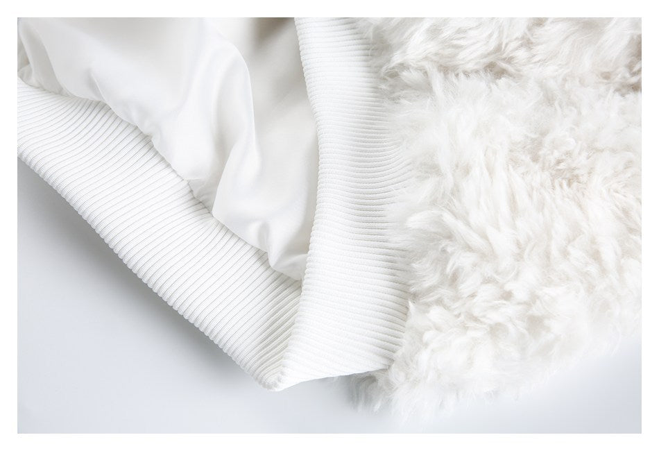 Close-up showing the jacket's white lining, fluffy outer fabric, and ribbed hem.
