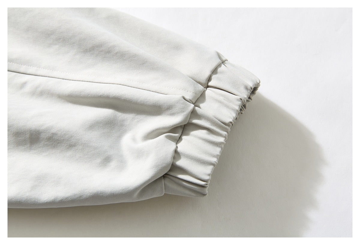 Close-up of a light gray garment sleeve ending in a gathered elastic cuff.