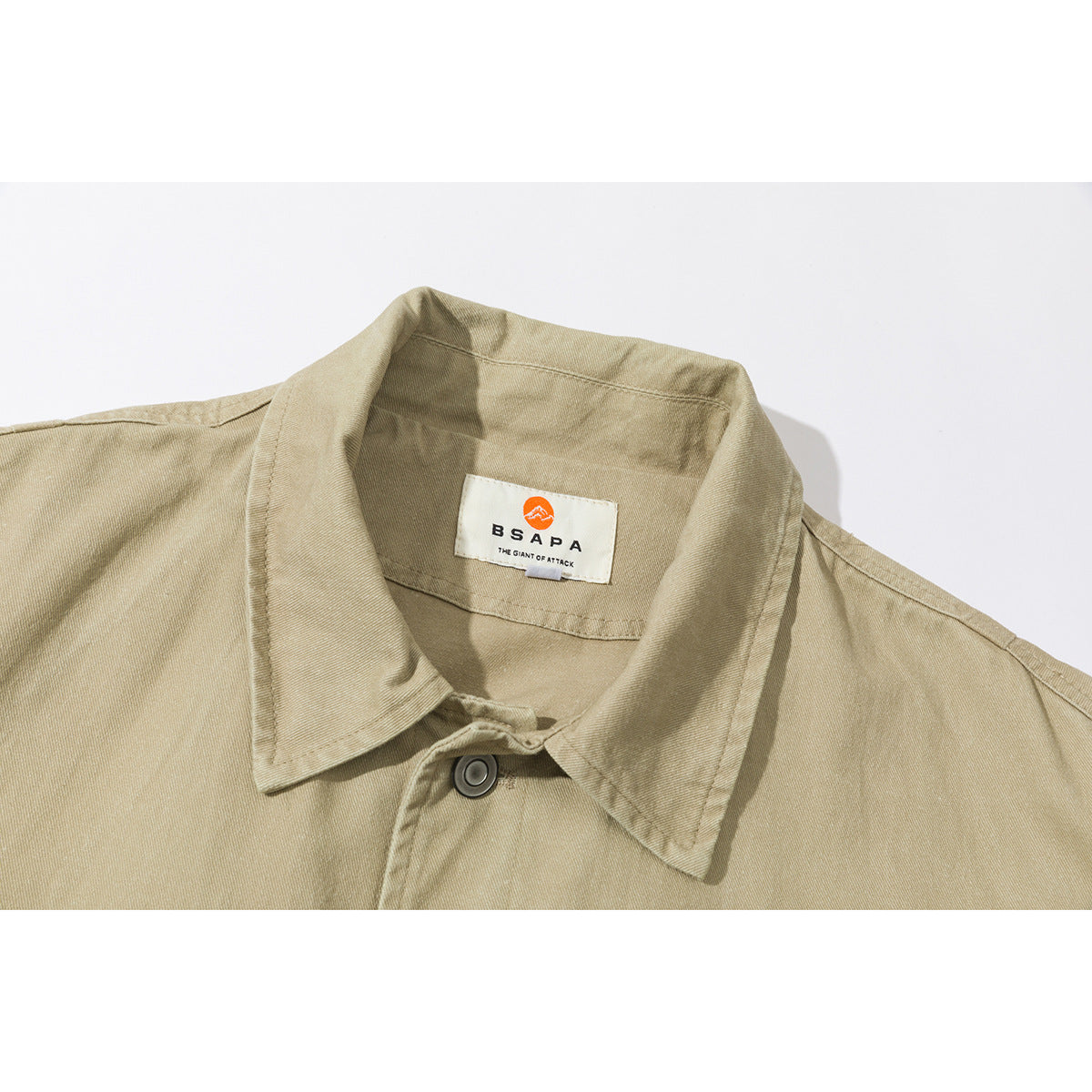 Close-up of a tan jacket collar, top button, and sewn neck label.