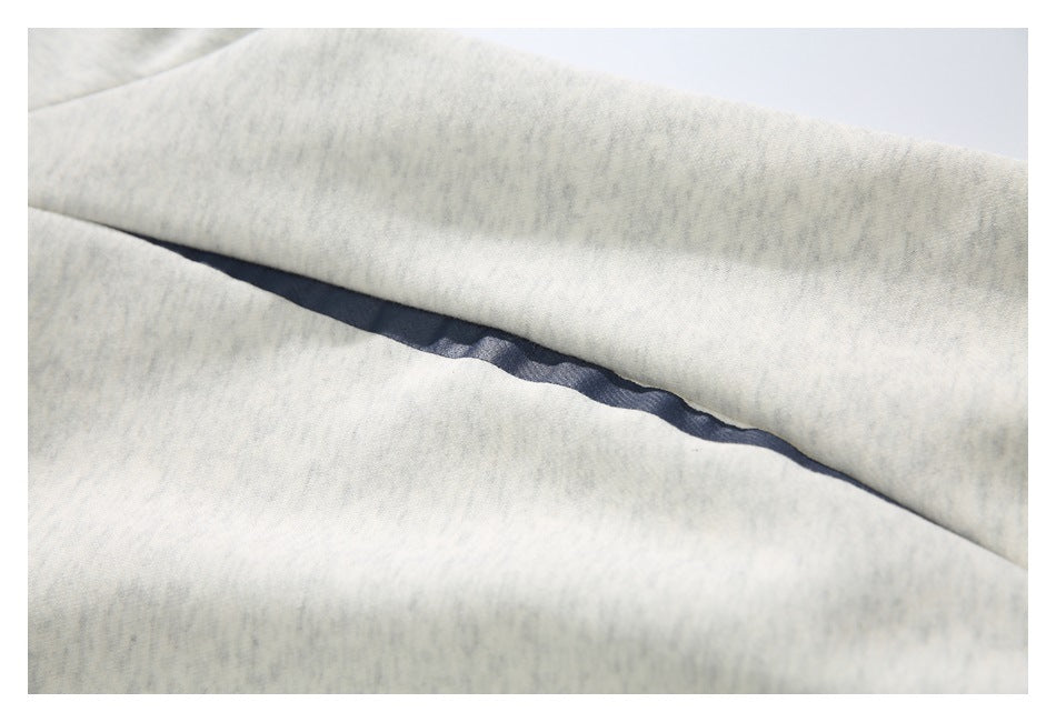 Close-up of a narrow navy insert or trim between sections of light gray sweatshirt fabric.
