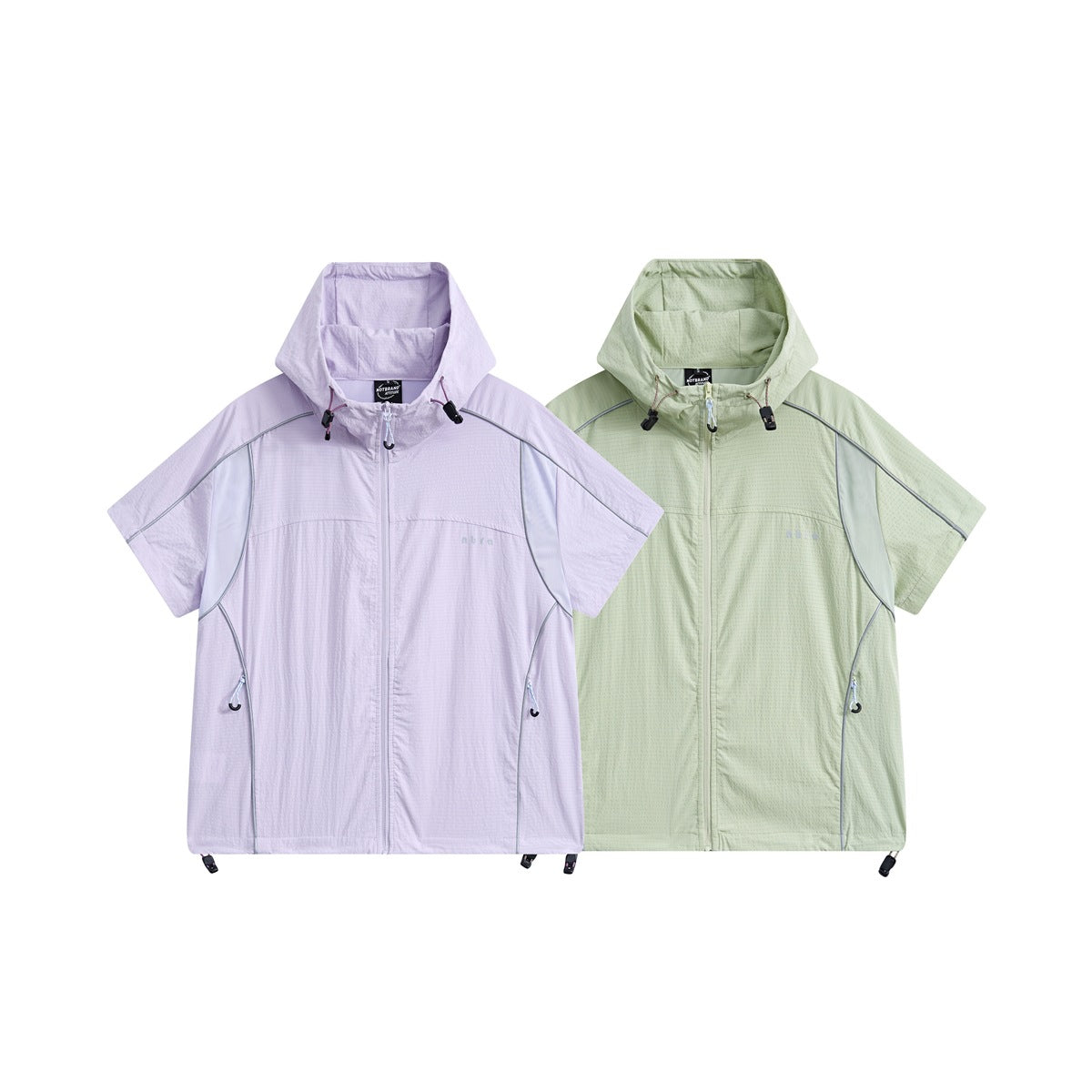 Front view of two short-sleeve hooded jackets, one pale lavender and one light green, with zippers and piping.